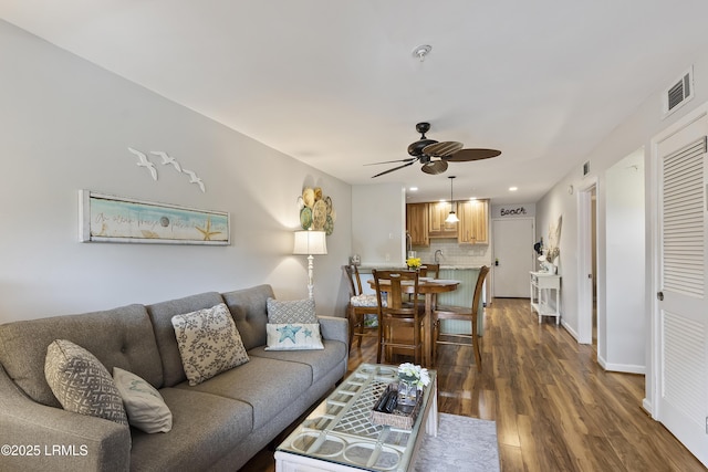 living room with ceiling fan, dark hardwood / wood-style flooring, and sink