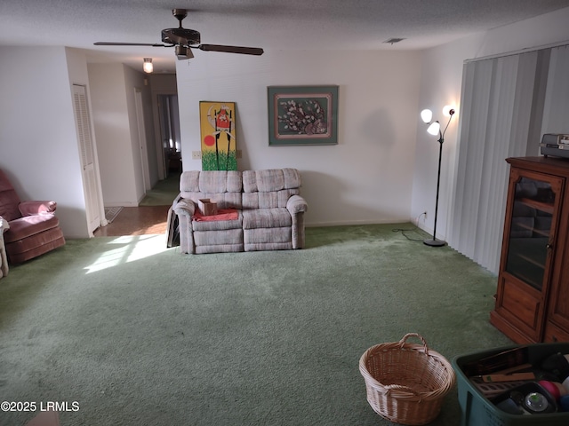 carpeted living room featuring ceiling fan and a textured ceiling