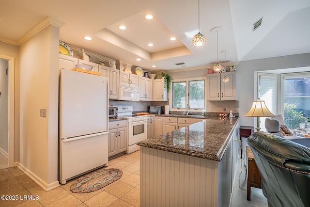 kitchen with sink, tasteful backsplash, decorative light fixtures, a tray ceiling, and white appliances