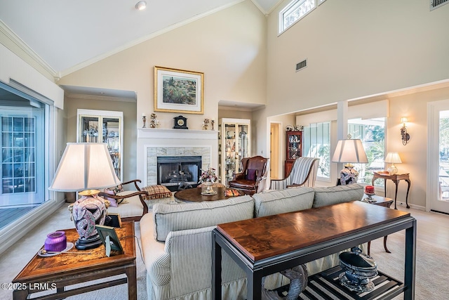 living room with high vaulted ceiling, crown molding, light colored carpet, and a premium fireplace