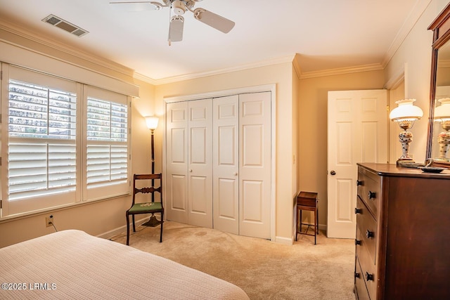 bedroom with light carpet, crown molding, a closet, and ceiling fan