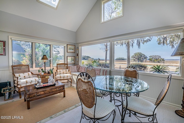 sunroom / solarium featuring a wealth of natural light and lofted ceiling with skylight