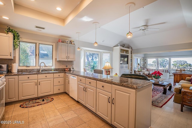 kitchen featuring a raised ceiling, pendant lighting, white dishwasher, and kitchen peninsula