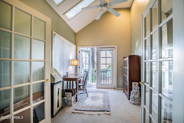 carpeted home office featuring a skylight, ceiling fan, high vaulted ceiling, and french doors