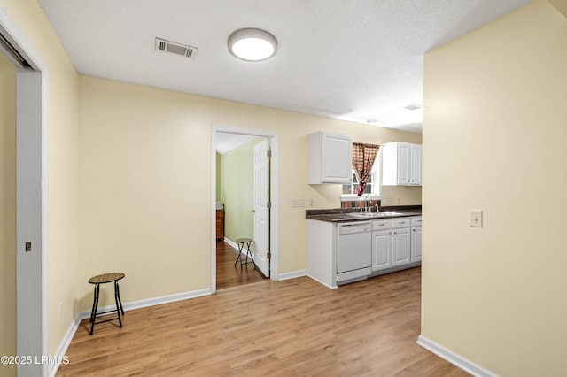 16 Star Magnolia Ct, Beaufort, SC 29907 - kitchen featuring white dishwasher, white cabinetry, light wood-style floors, dark countertops, and a sink
