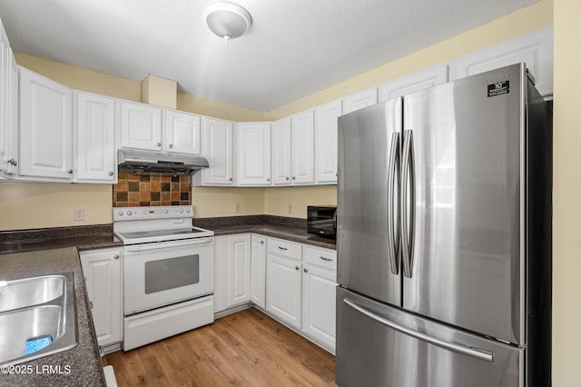 16 Star Magnolia Ct, Beaufort, SC 29907 - kitchen featuring freestanding refrigerator, electric range, under cabinet range hood, dark countertops, and white cabinets