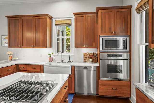 105 Bartram Dr, Beaufort, SC 29902 - kitchen featuring appliances with stainless steel finishes, tasteful backsplash, light stone countertops, and brown cabinets