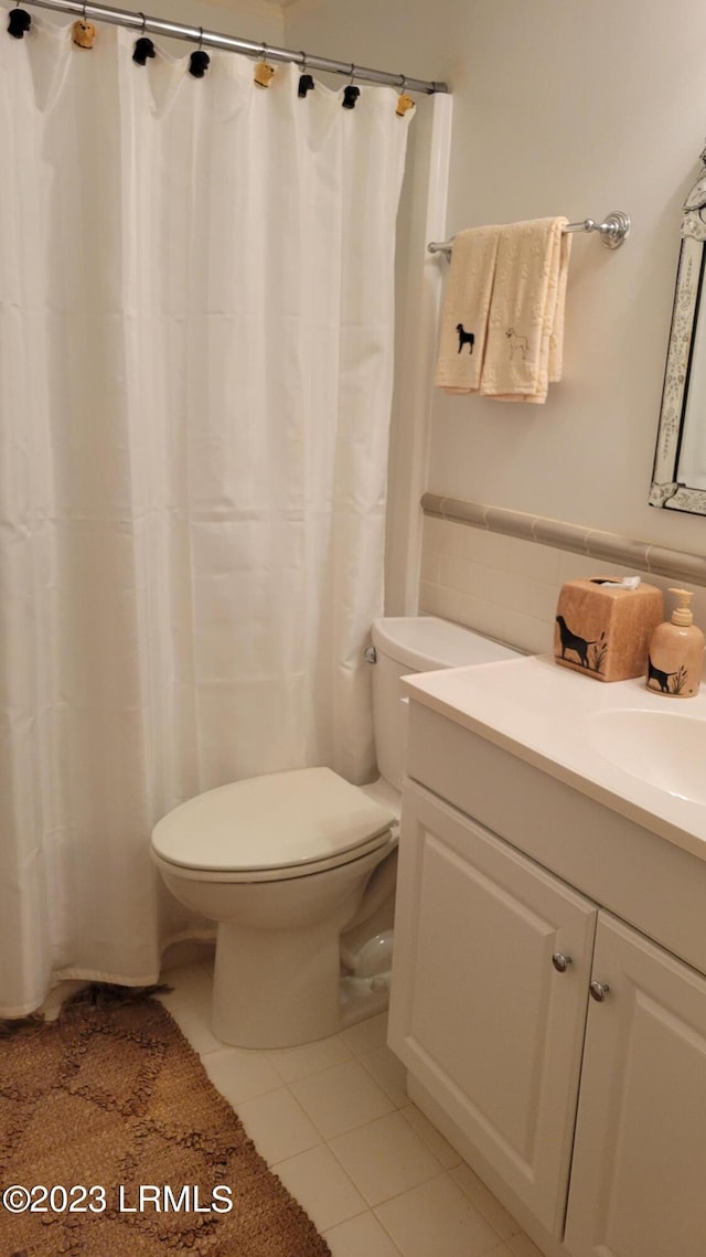 bathroom featuring tile patterned flooring, vanity, and toilet