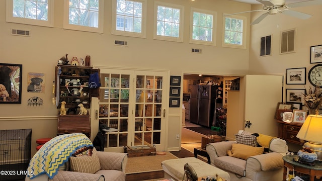 living room featuring a towering ceiling and ceiling fan