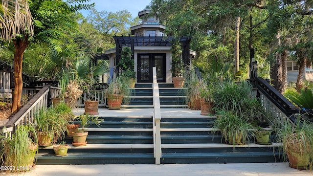 entrance to property with a pergola and french doors