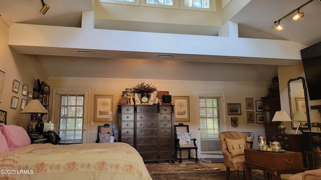 bedroom featuring rail lighting and vaulted ceiling