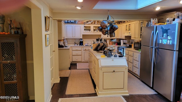 kitchen with a kitchen island, appliances with stainless steel finishes, sink, cream cabinets, and dark wood-type flooring