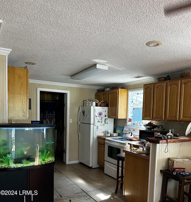 kitchen featuring light tile patterned flooring, a breakfast bar, crown molding, kitchen peninsula, and white appliances