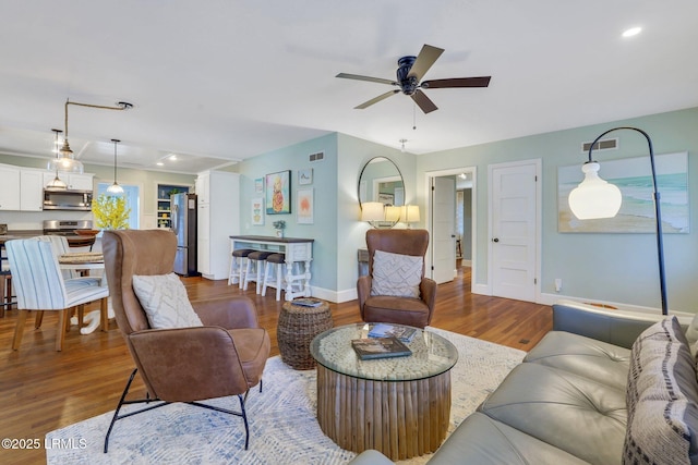 living room with recessed lighting, baseboards, visible vents, a ceiling fan, and wood finished floors