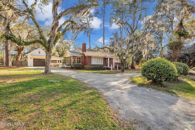 view of front facade featuring a chimney, fence, aphalt driveway, a front lawn, and a garage