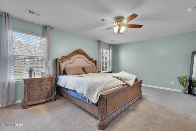 bedroom featuring light carpet, visible vents, multiple windows, and baseboards