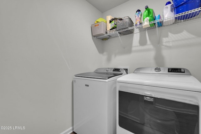 washroom featuring baseboards, independent washer and dryer, and laundry area