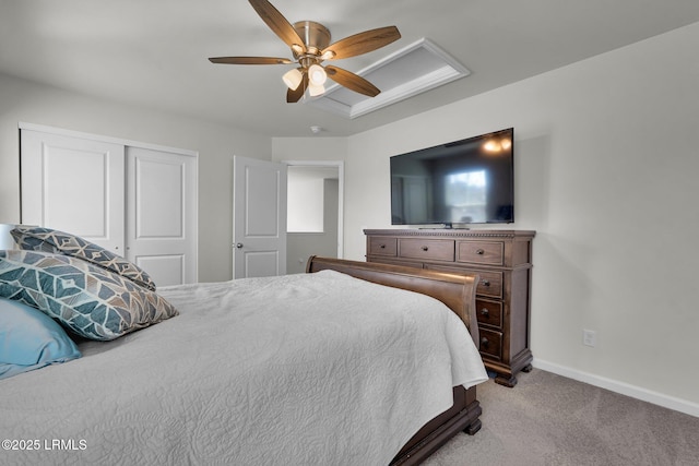 bedroom with a closet, carpet floors, baseboards, attic access, and ceiling fan