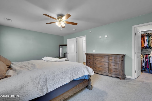 carpeted bedroom featuring visible vents, a ceiling fan, a closet, baseboards, and a spacious closet