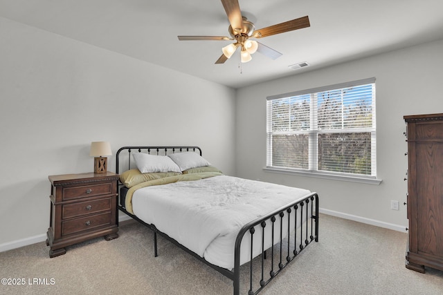 bedroom with visible vents, light colored carpet, baseboards, and ceiling fan