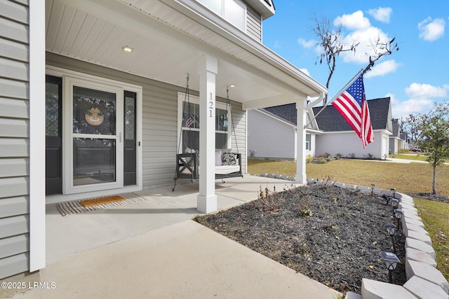 entrance to property with a lawn and a porch