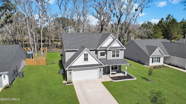 traditional-style house featuring board and batten siding, fence, covered porch, a garage, and driveway