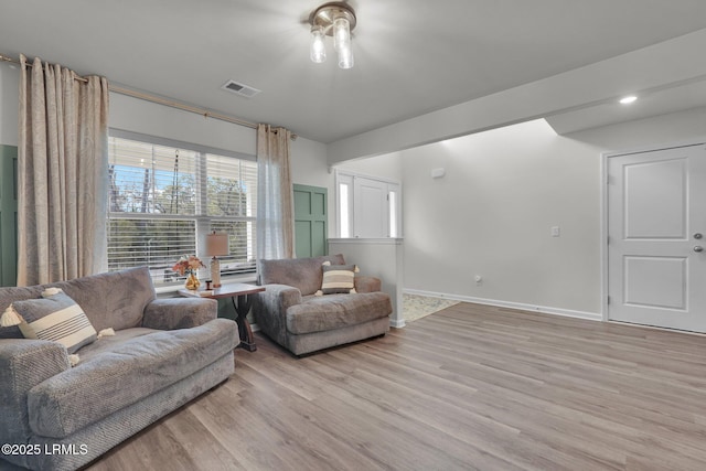 living room featuring visible vents, wood finished floors, and baseboards