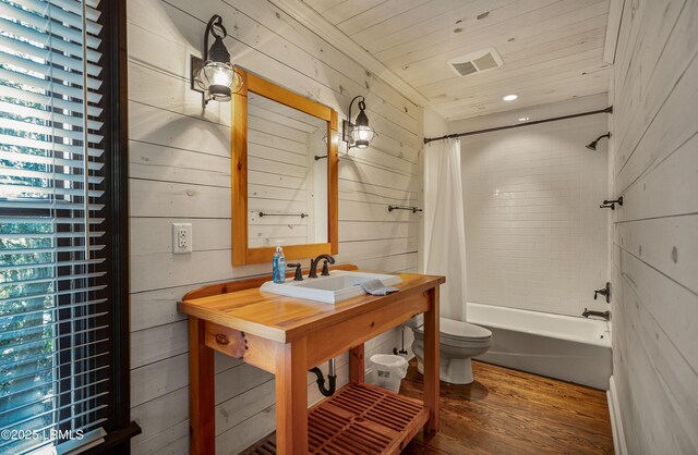 full bathroom featuring hardwood / wood-style flooring, toilet, sink, and shower / bath combo