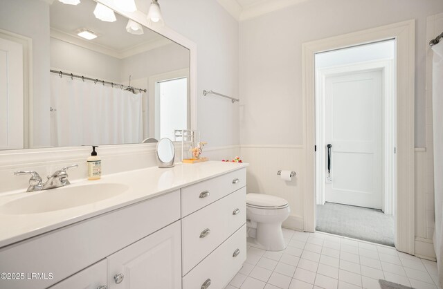 bathroom with vanity, tile patterned flooring, ornamental molding, and toilet