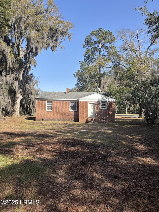 view of home's exterior featuring a lawn and brick siding