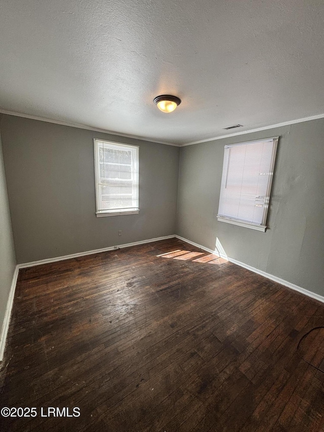 unfurnished room with ornamental molding, hardwood / wood-style floors, a textured ceiling, and baseboards