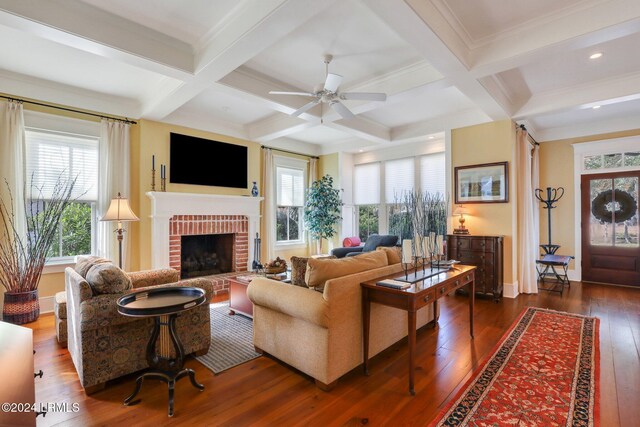 living room with beamed ceiling, dark hardwood / wood-style floors, coffered ceiling, and a fireplace