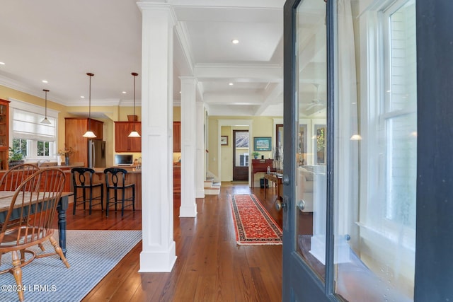 hall with ornamental molding, decorative columns, dark hardwood / wood-style floors, and beamed ceiling