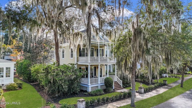 view of front facade featuring a balcony and a front yard