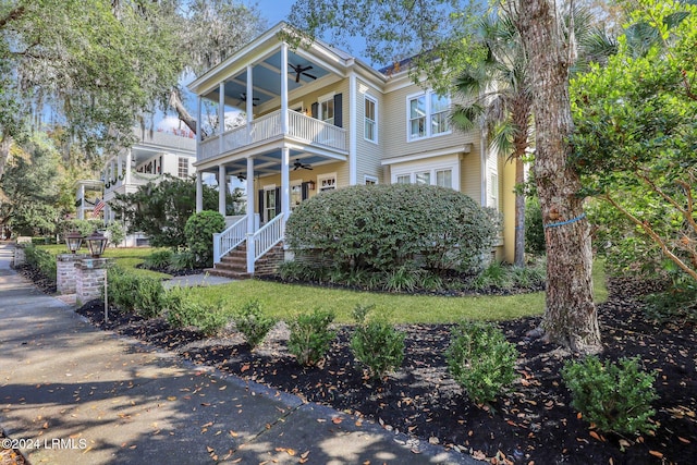 view of front of property featuring ceiling fan and a balcony