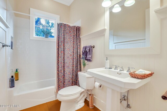 bathroom with toilet, hardwood / wood-style floors, and shower / bath combo with shower curtain