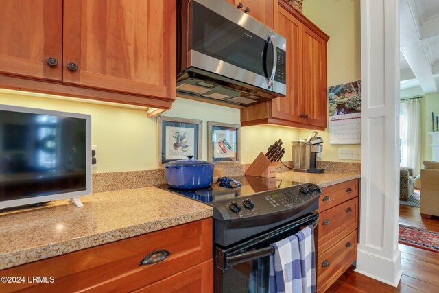 kitchen with wood-type flooring, black range with electric stovetop, and light stone countertops