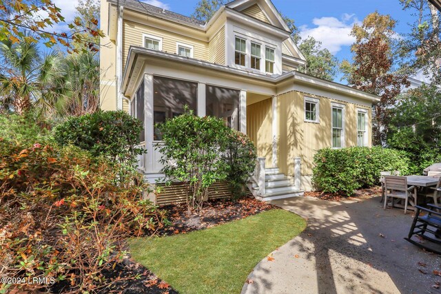 view of front of property with a sunroom and a patio