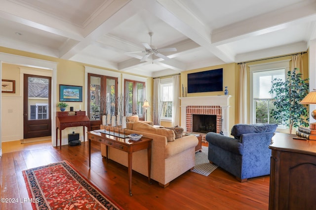 living room with coffered ceiling, a fireplace, and beam ceiling