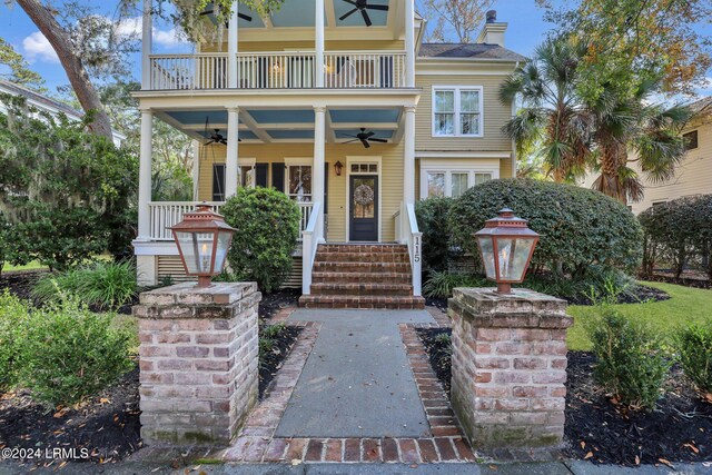 view of front of home with ceiling fan and a balcony