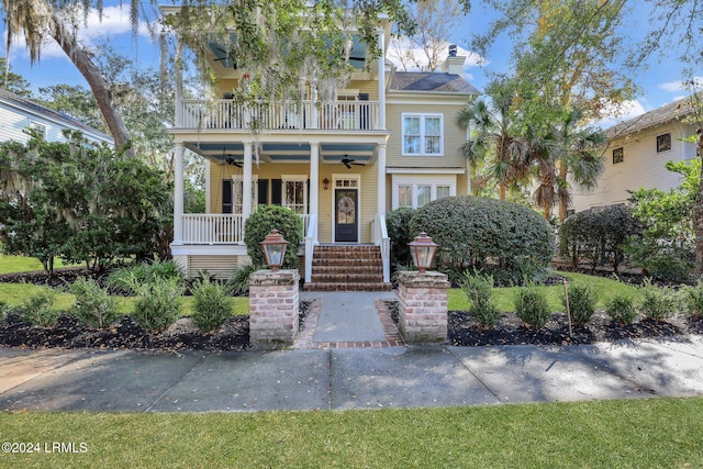 view of front facade with ceiling fan, a porch, and a balcony