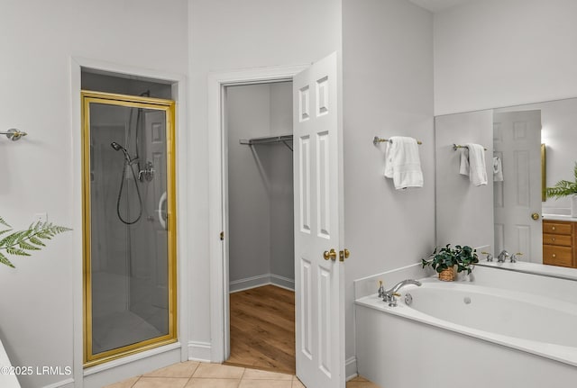 bathroom featuring tile patterned flooring, a shower stall, and a bath