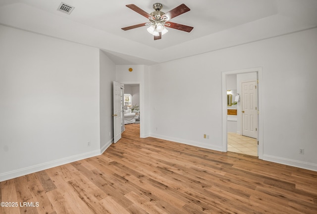 empty room featuring visible vents, baseboards, light wood-type flooring, and ceiling fan