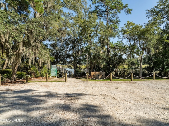 view of yard with volleyball court and gravel driveway