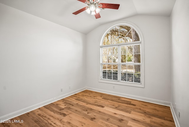 spare room with vaulted ceiling, ceiling fan, baseboards, and wood finished floors