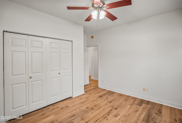 unfurnished bedroom featuring a closet, ceiling fan, light wood-type flooring, and baseboards