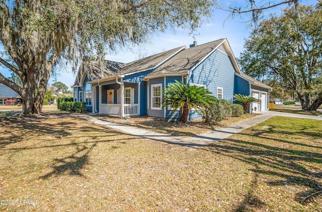 view of front of house with covered porch, an attached garage, driveway, and a front yard