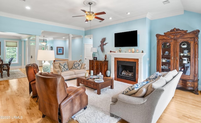 living area featuring recessed lighting, light wood-style floors, a fireplace, crown molding, and ceiling fan