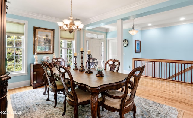 dining space featuring a notable chandelier, light wood-style floors, a healthy amount of sunlight, and ornamental molding