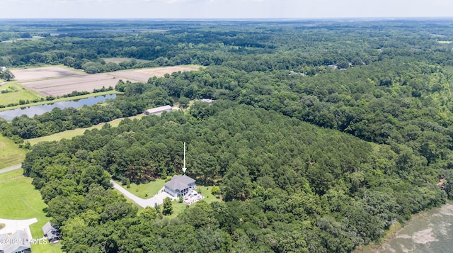 drone / aerial view featuring a wooded view and a water view